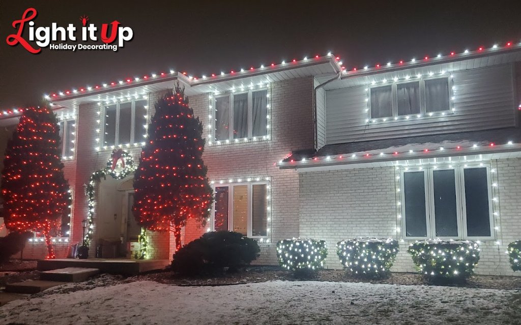 Red and white roofline, bush and tree Christmas lights on brick home