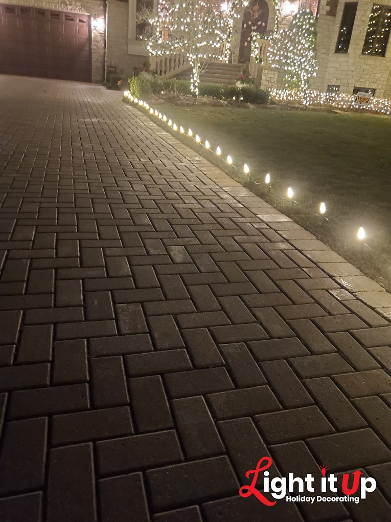Warm white driveway pathway Christmas lights leading to decorated home