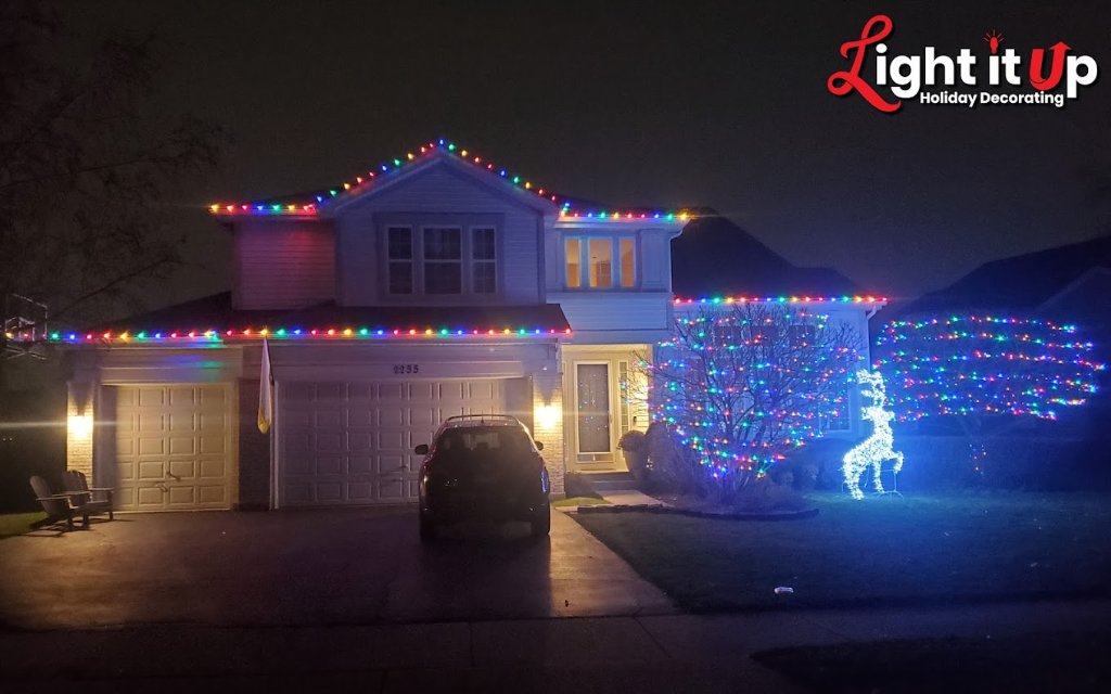 Multicolor roofline and bush Christmas lights with lit reindeer
