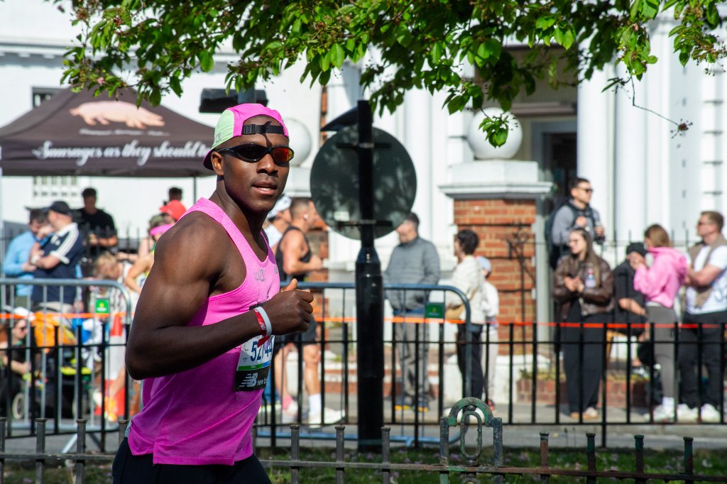 Two runners celebrating and waving as they pass