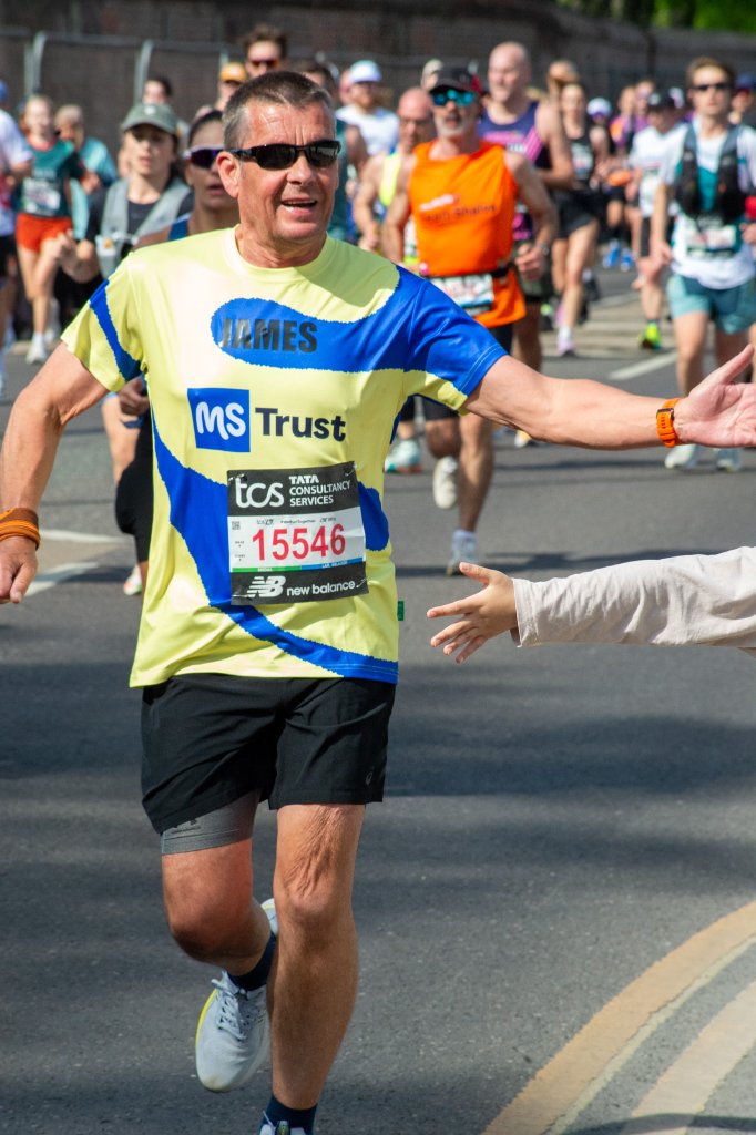 Jonny Young Lives vs Cancer runner high-fiving a spectator