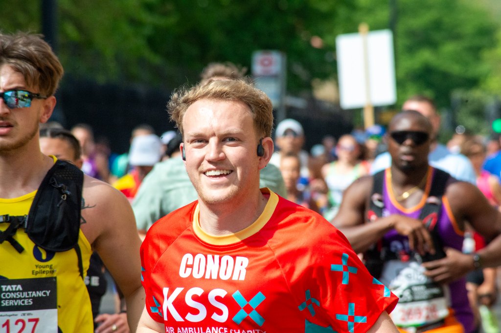 Runners on a wide avenue toward the London skyline