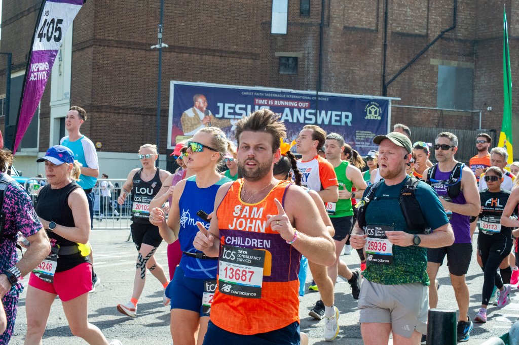 Runners with a London Marathon mural in SE London