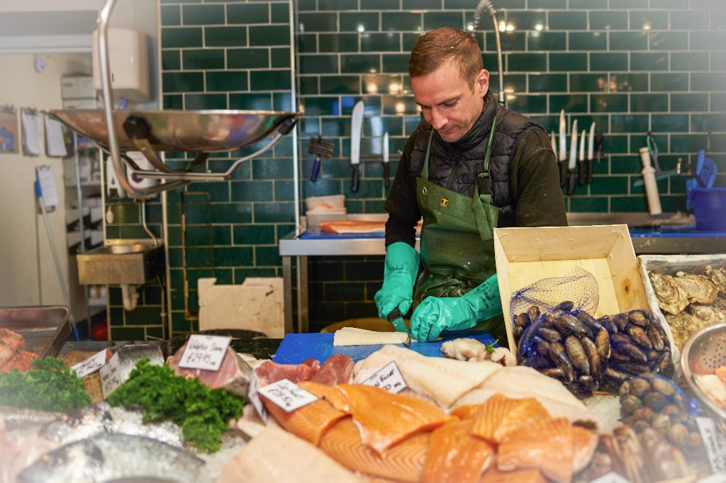 Fishmonger preparing fresh seafood on ice