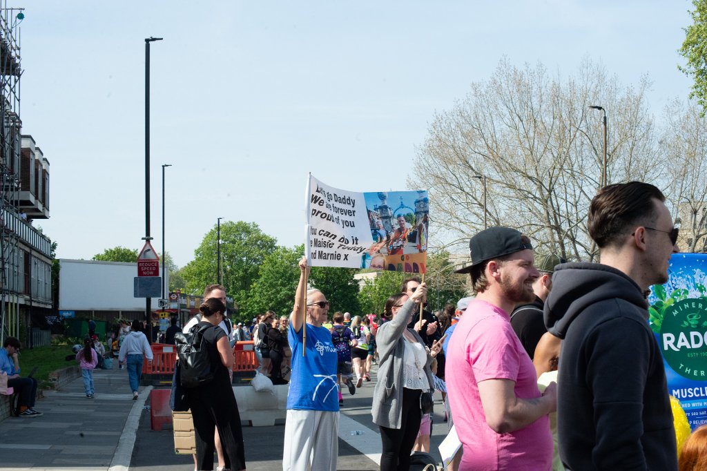 Spectators cheering with foam hands near the finish