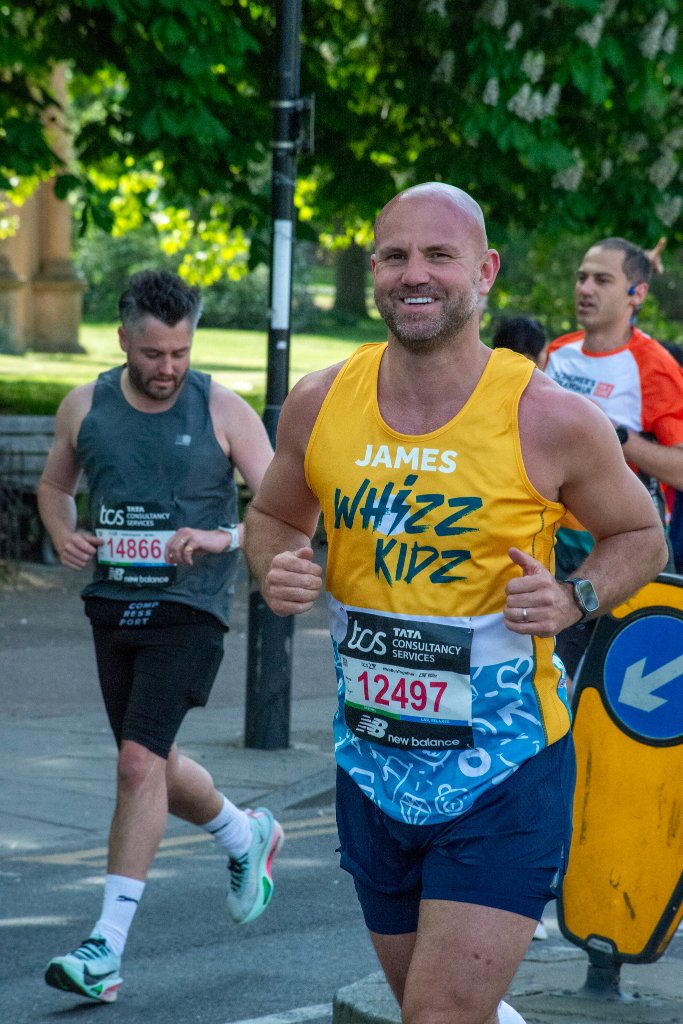 Large crowd of runners approaching the finish with the London skyline