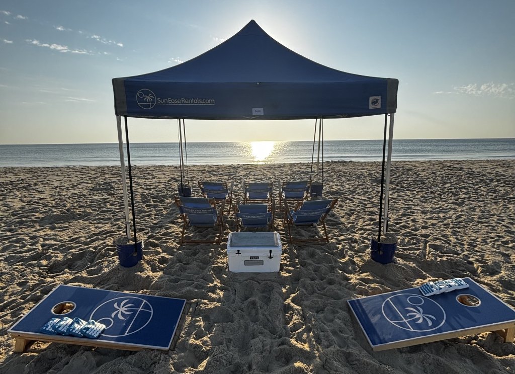 Professional beach tent rental setup with chairs and cooler on Outer Banks sand