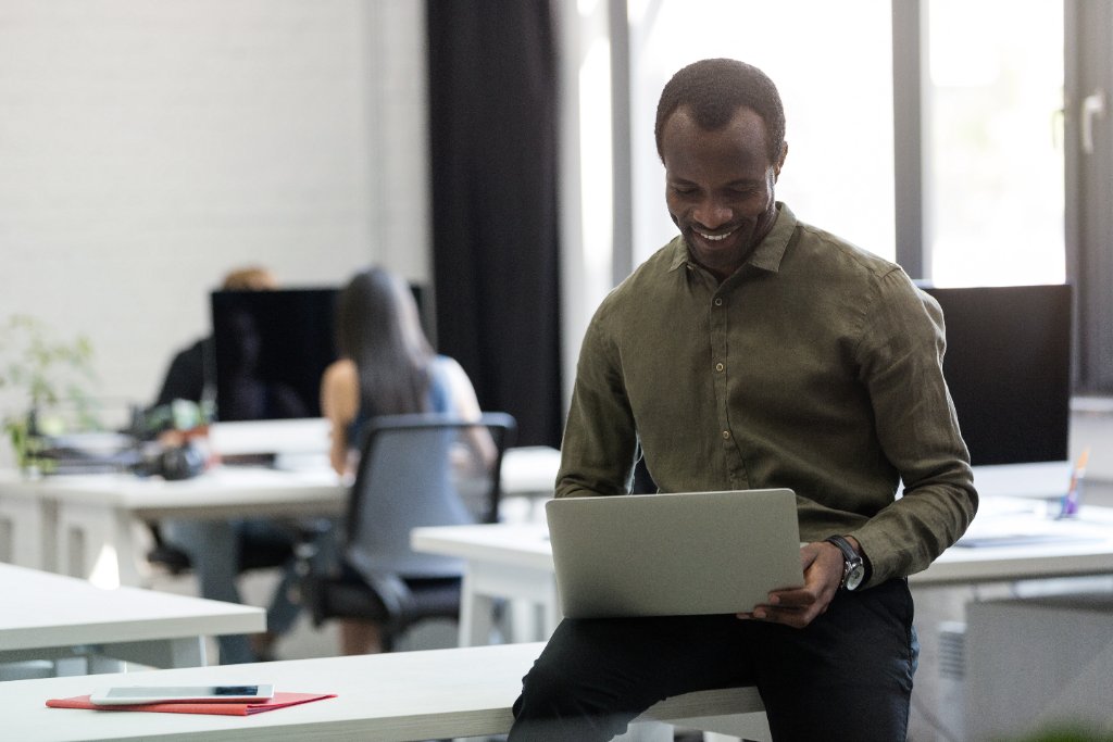 Happy African candidate at his desk after a successful hire