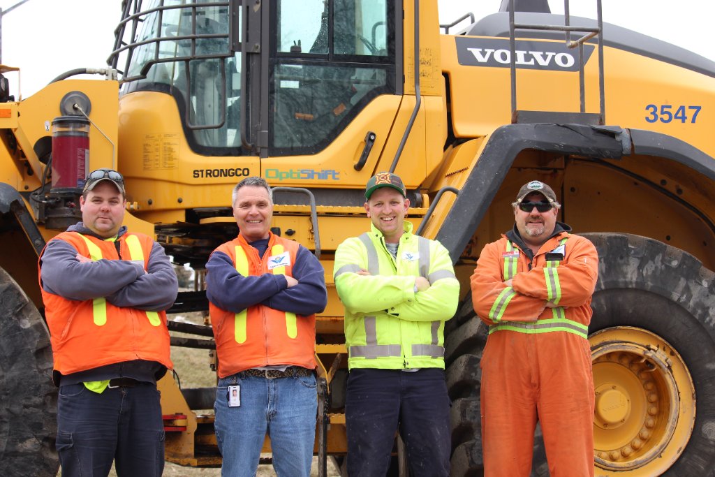Construction crew in front of Volvo loader