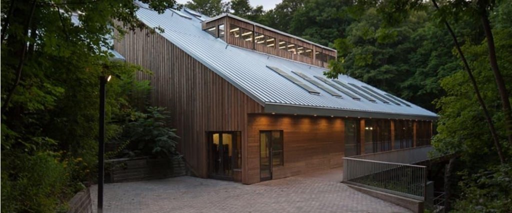 Kortright Centre for Conservation at evening with warm lighting surrounded by forest