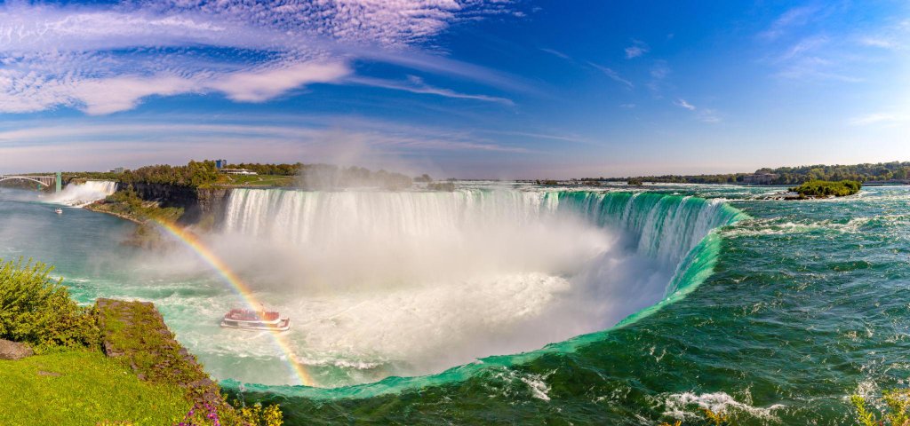 Panoramic view of Niagara Falls with rainbow