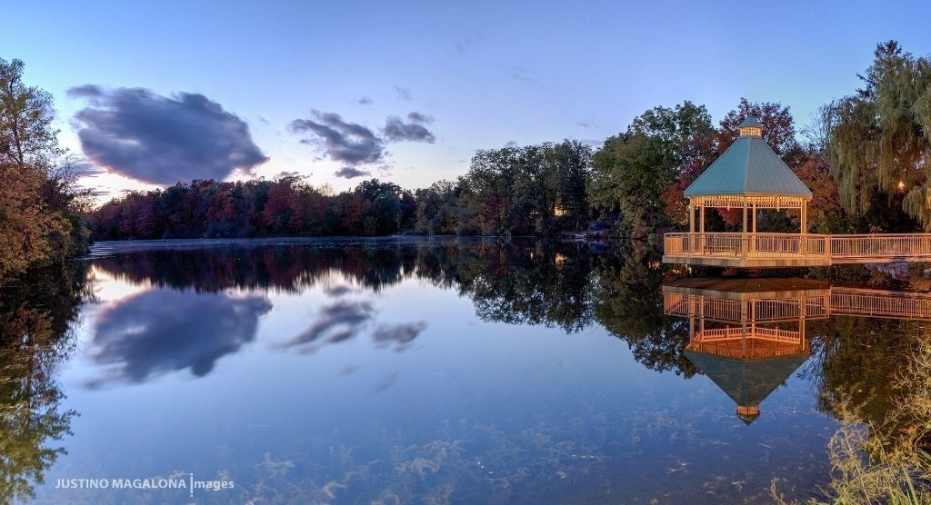 Mill Pond gazebo on pier reflected in calm water at dusk