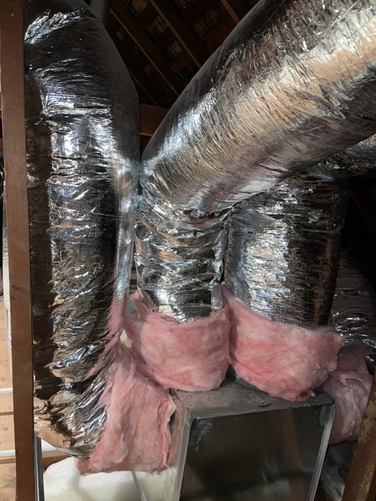 Attic space with cobwebs and debris near chimney