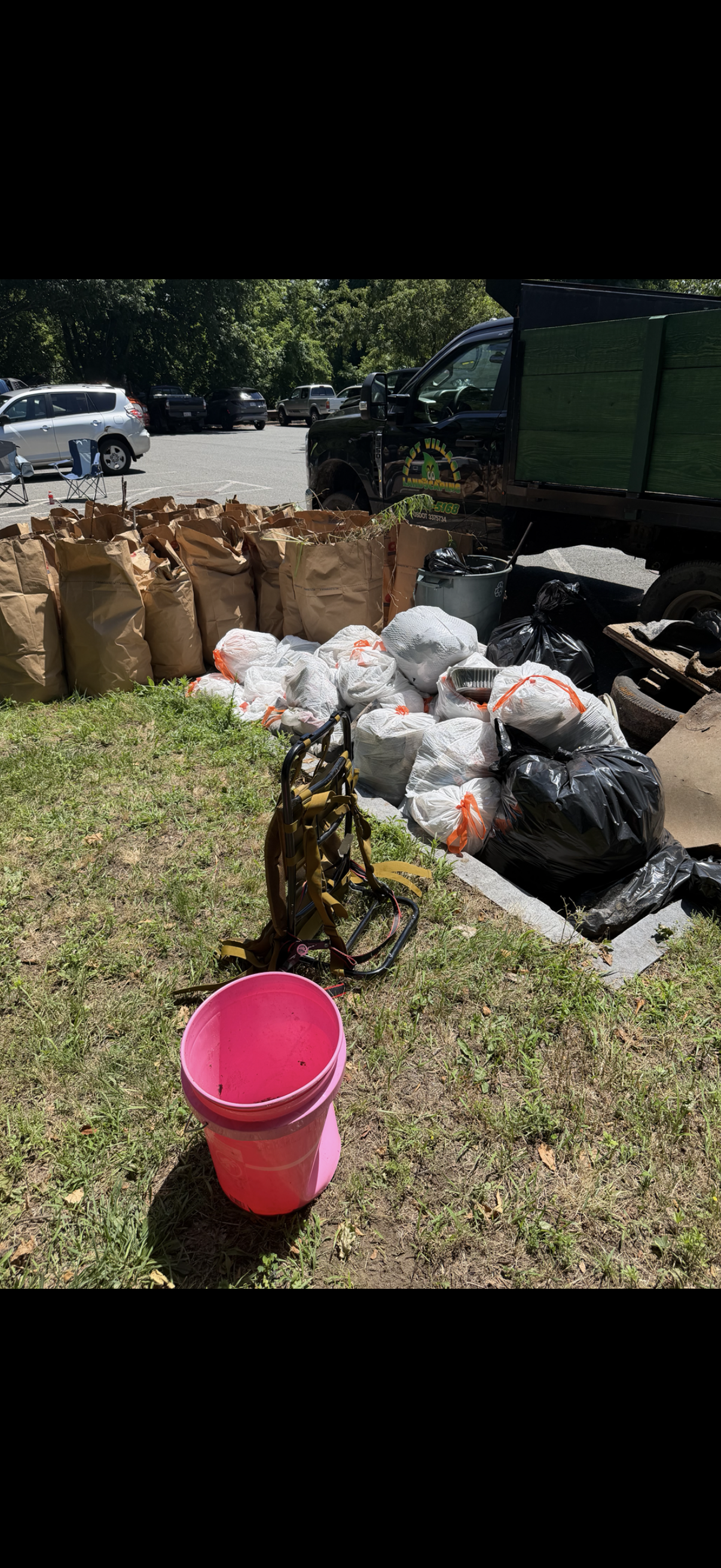 Real community cleanup — bags of collected litter, supplies, and equipment after a volunteer cleanup effort