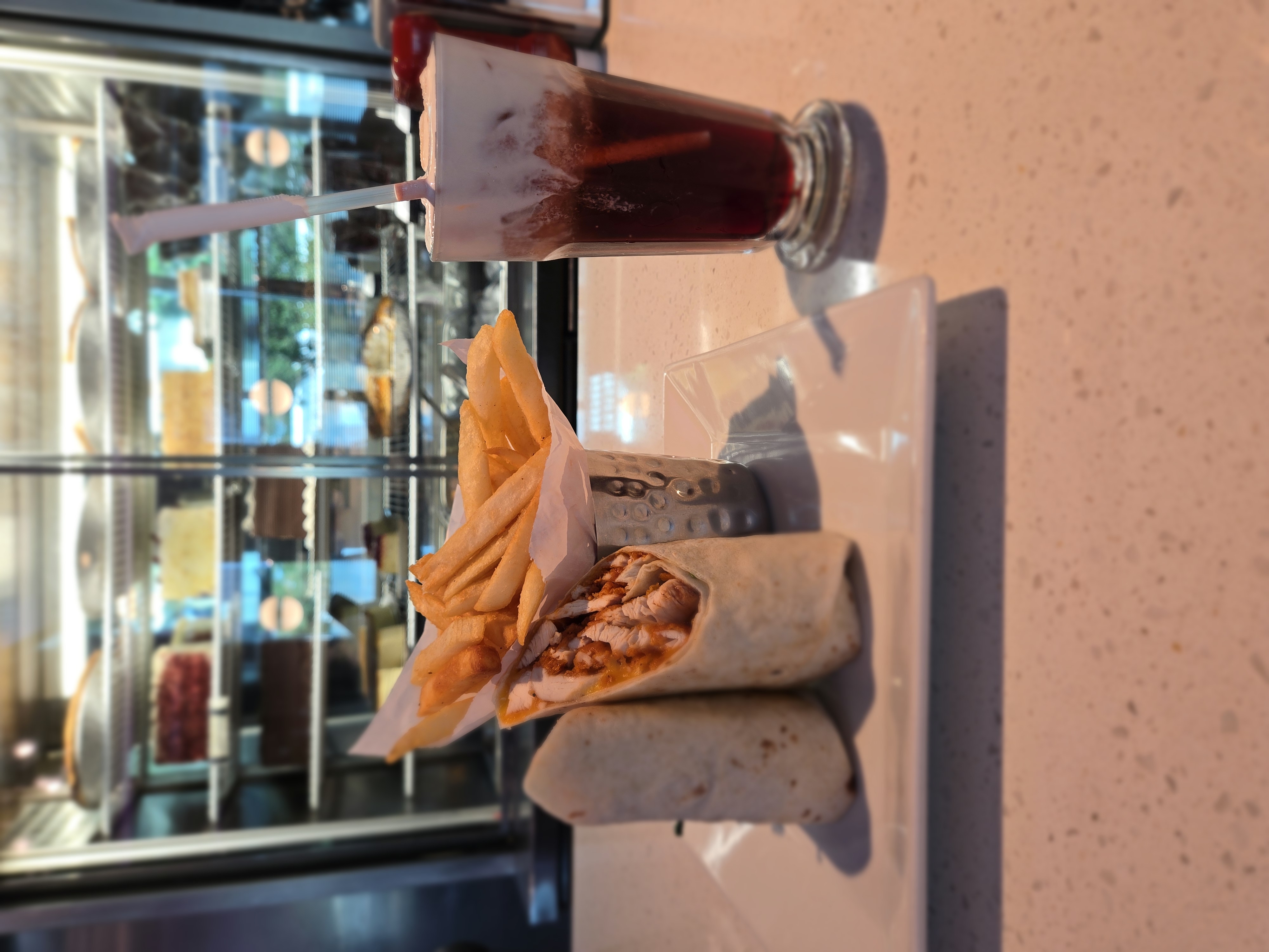 Grilled chicken wrap cut in half with french fries