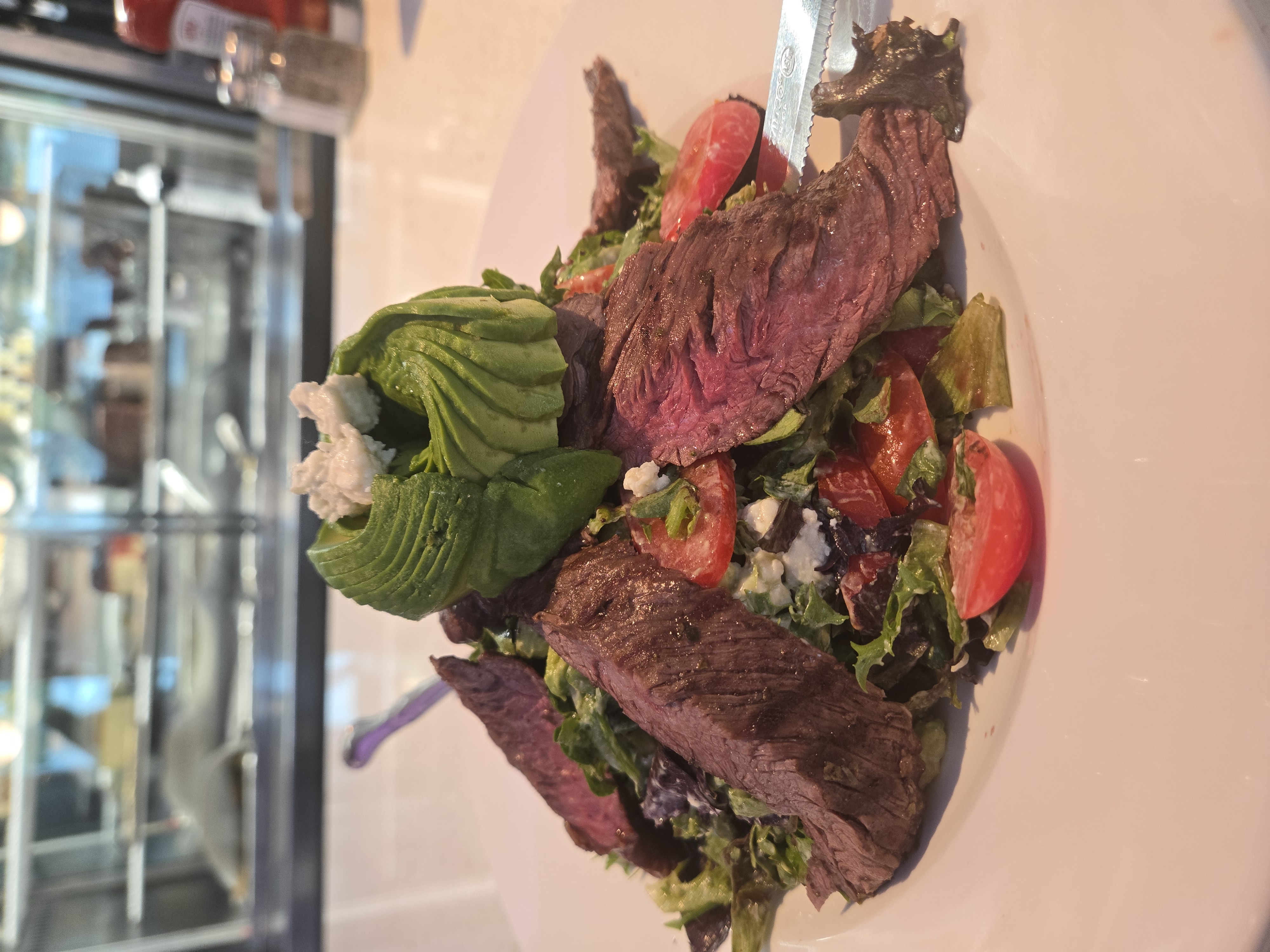 Steakhouse salad with sliced steak and avocado