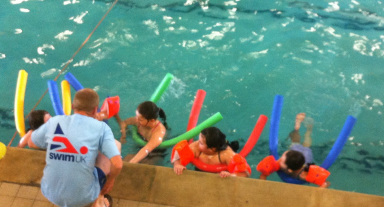 Swimming instructor with children during a school lesson