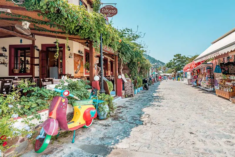 Colorful cobblestone street lined with tavernas and gift shops in Zia Village, Kos