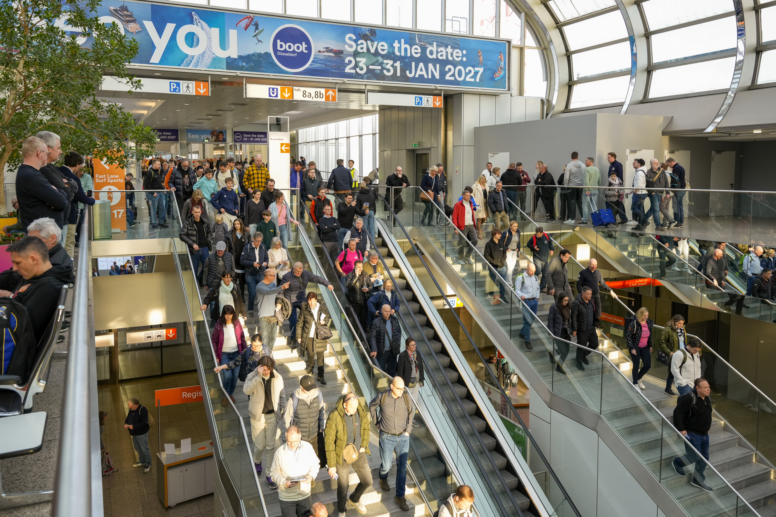Bezoekers bij de roltrappen op boot Düsseldorf 2026, onder een aankondiging voor de editie van 2027.
