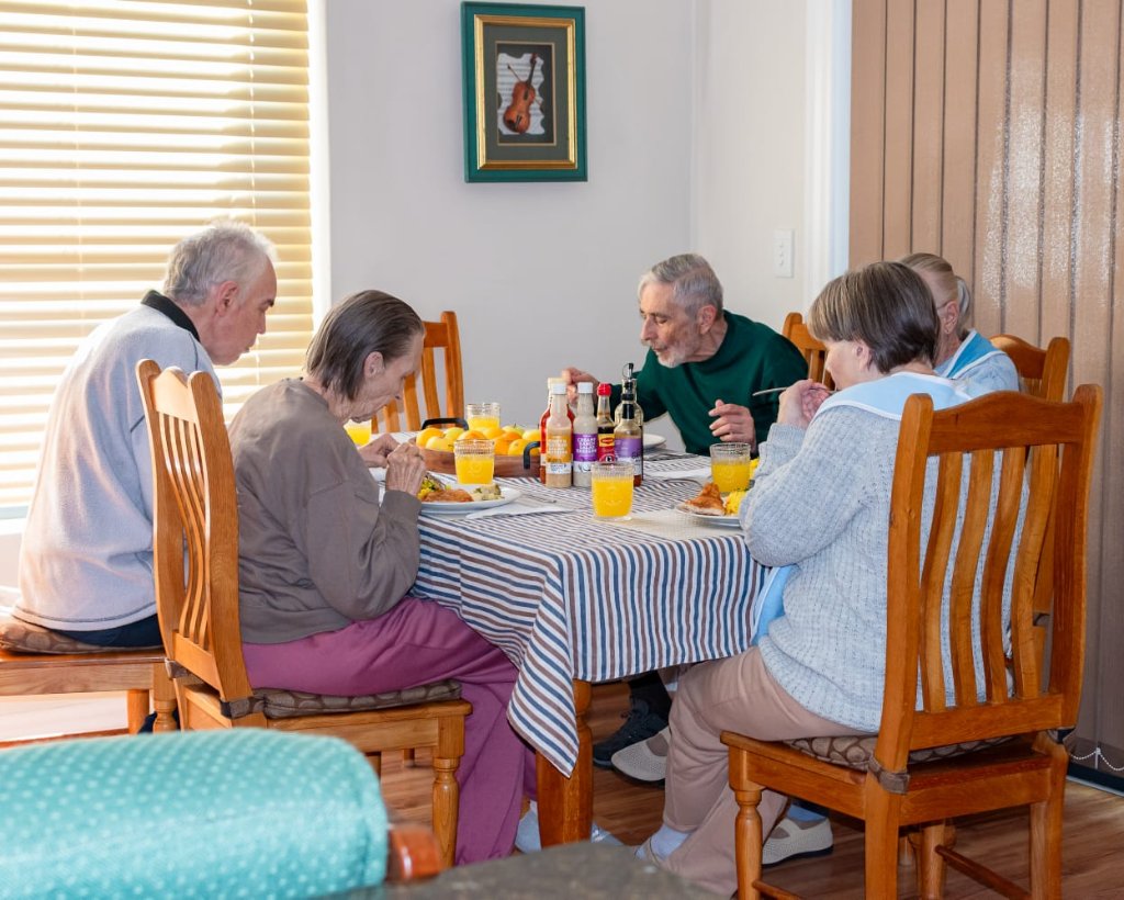 Carer and resident playing dominoes outdoors