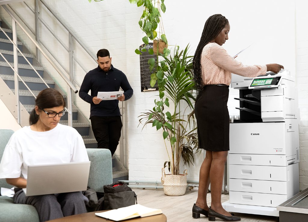 Canon imageRUNNER multifunction printer in a modern office with employees collaborating