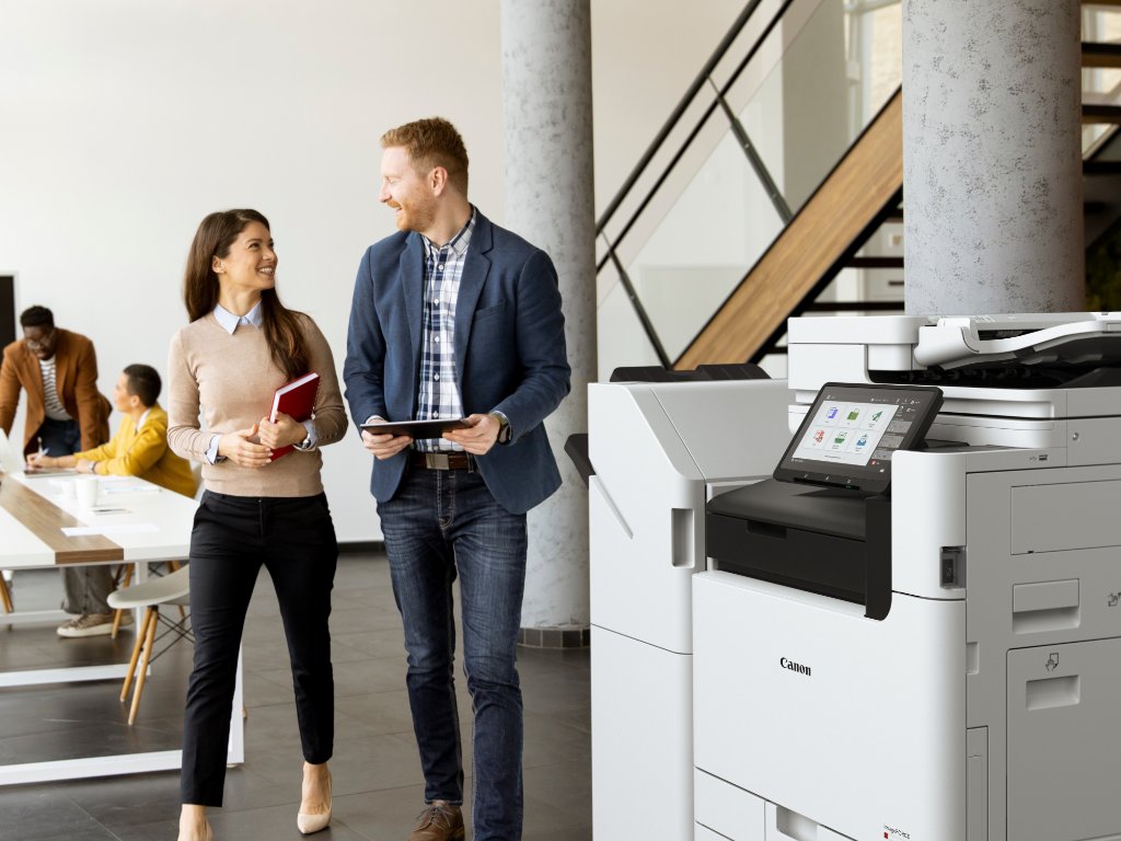 Close-up of a Canon multifunction printer with a touchscreen interface and a printed document