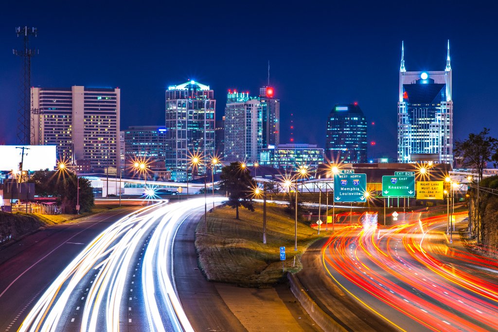 Nashville, Tennessee skyline at night with light trails on the highway