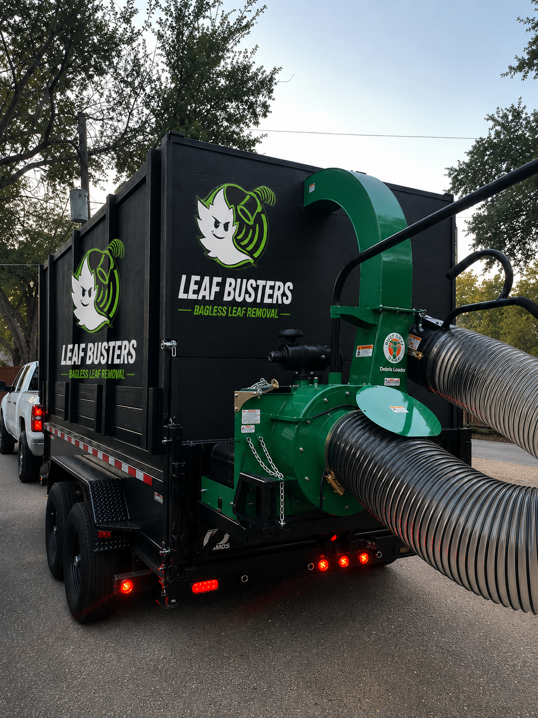 Leaf Busters bagless leaf removal trailer and truck-mounted Billy Goat vacuum loader parked on a DFW street — the 37hp commercial equipment that hauls every leaf away with zero bags