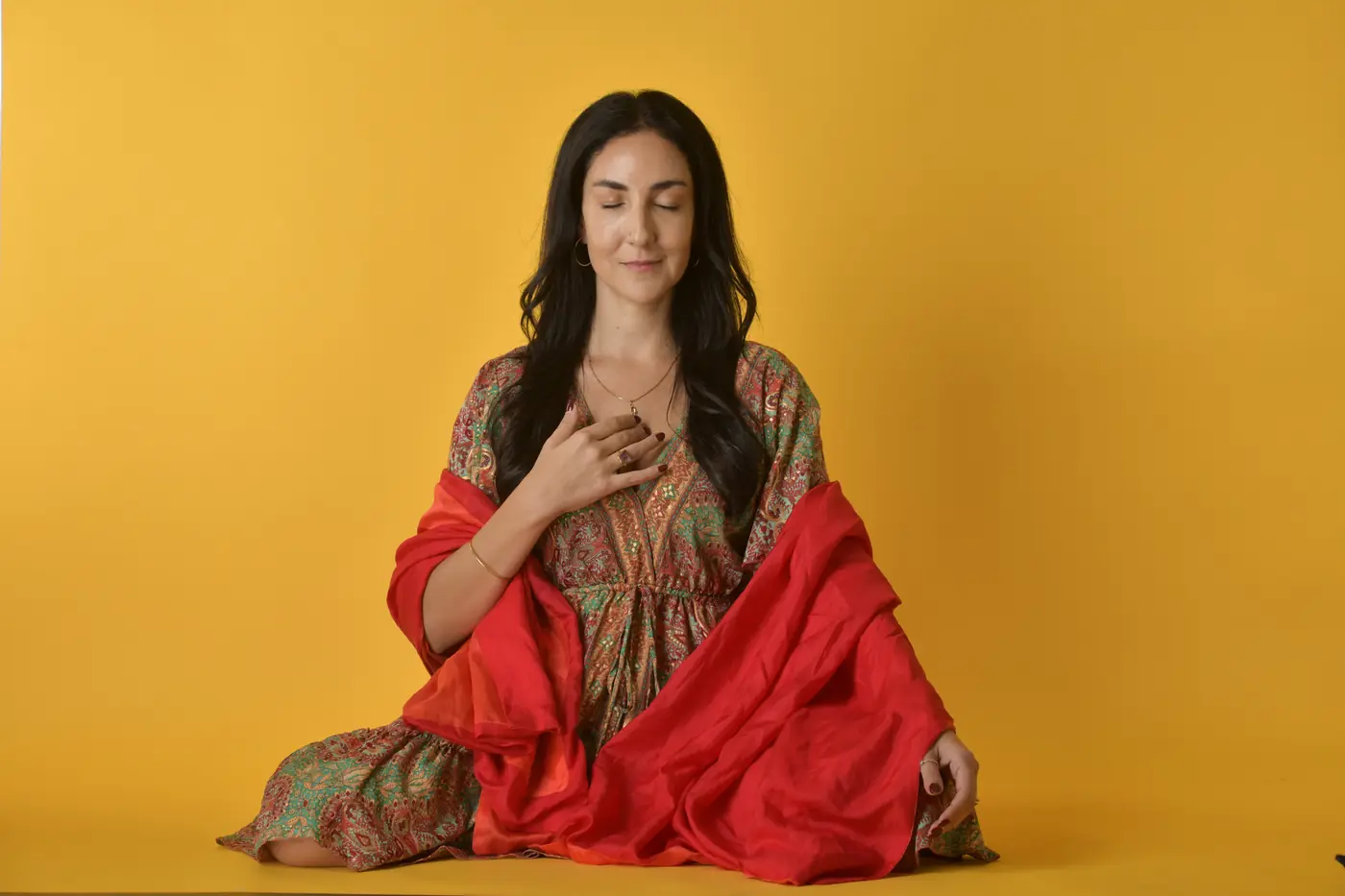 Camila Healing con los ojos cerrados y la mano en el pecho