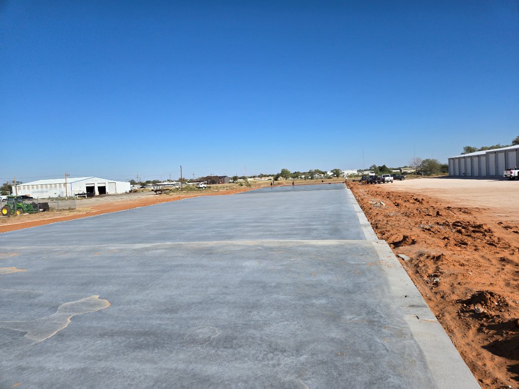 Large freshly poured commercial concrete slab on a rural job site