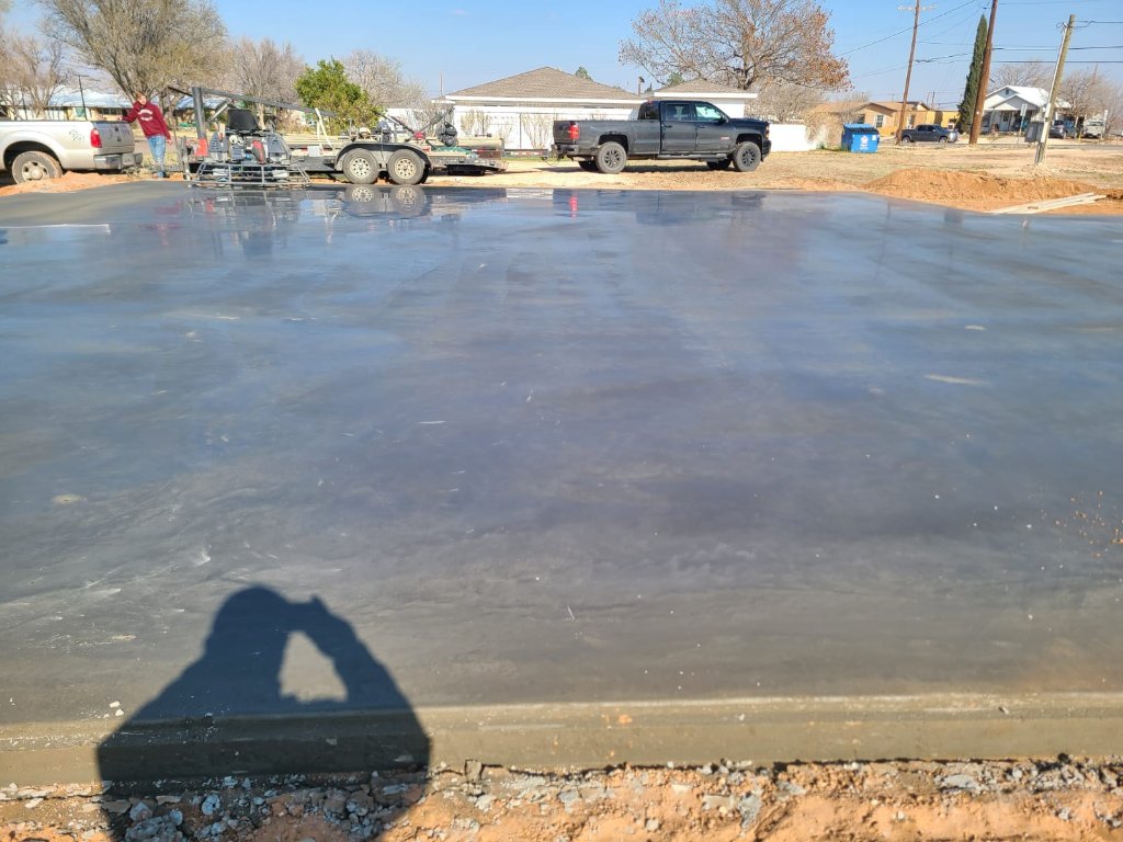 Freshly poured concrete slab with power trowel finishing equipment