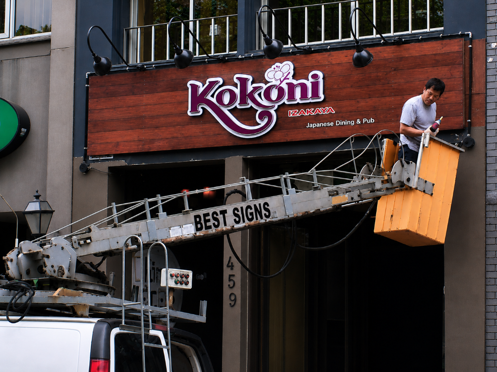 BestSigns founder installing signage on-site at Kokoni Izakaya