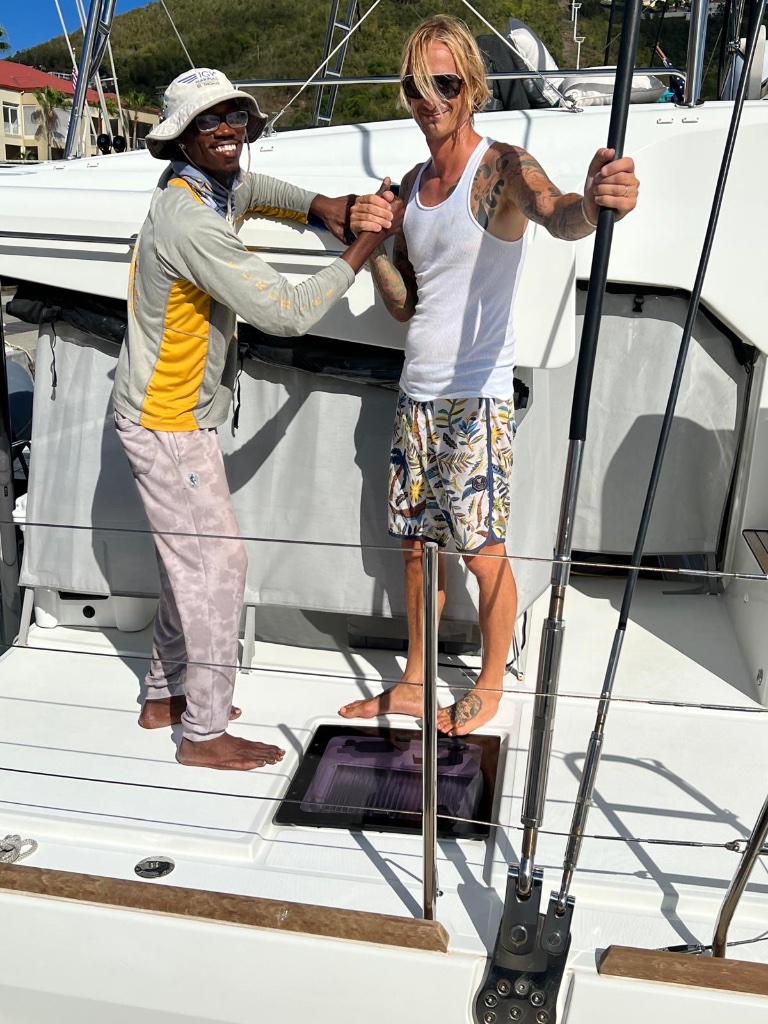 Deshawn and client shaking hands on sailboat deck — Scrubbies Boat Wash 340 USVI