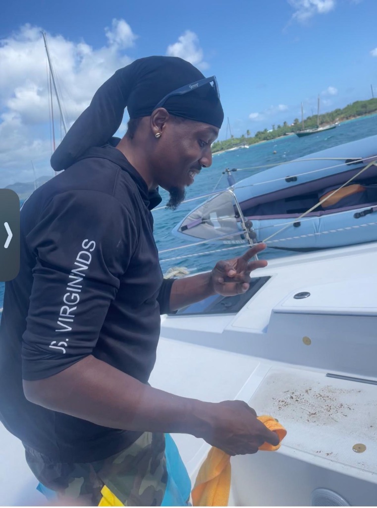 Deshawn cleaning catamaran deck — marine detailing USVI