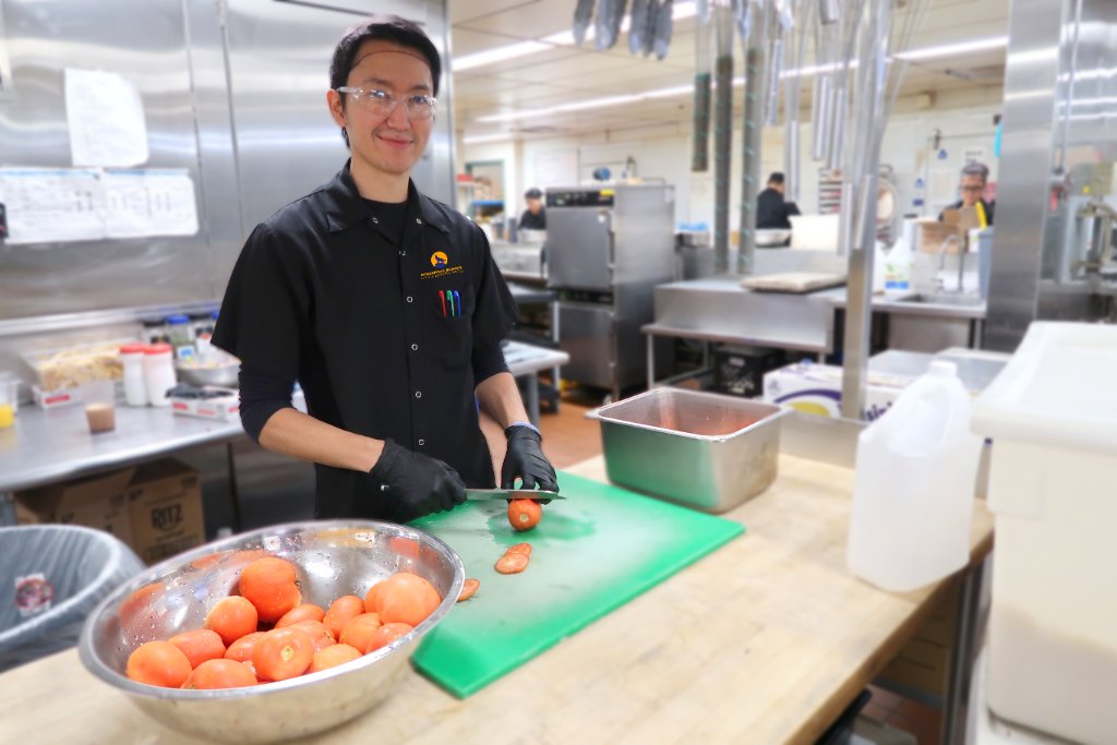 Chef hands plating a dish with traditional ingredients