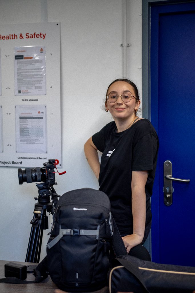 Videographer from Example Marketing capturing behind-the-scenes footage during a client content day for brand social media
