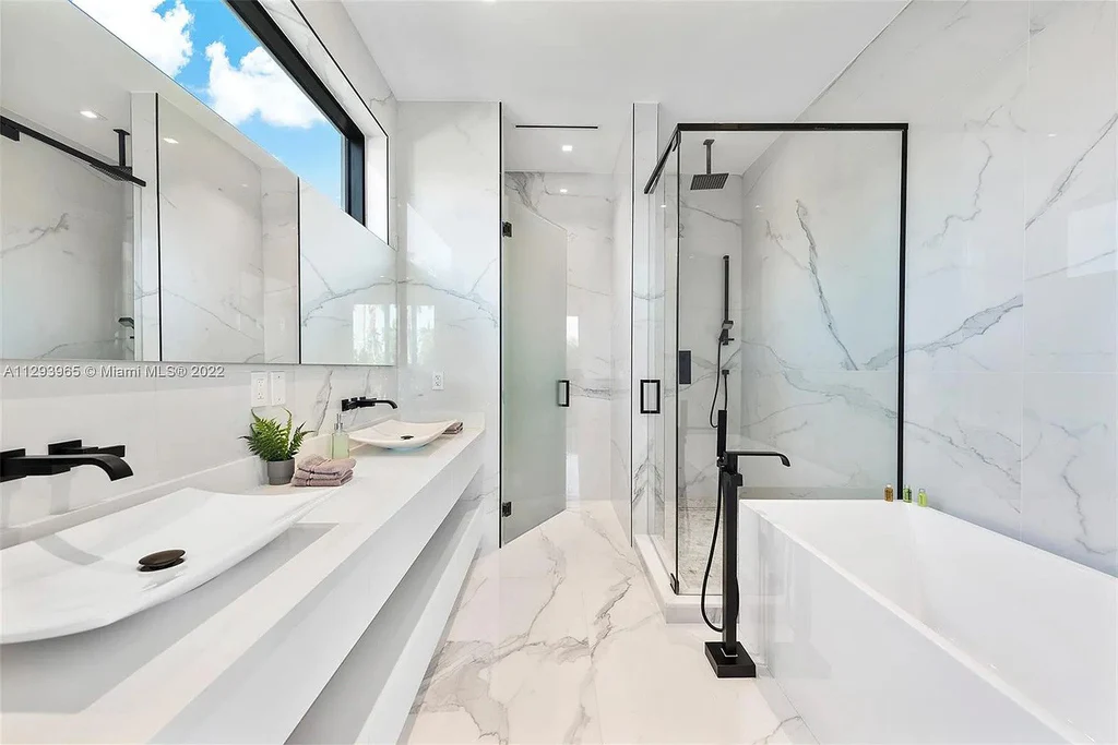 Bathroom with large format tile, a glass shower enclosure, and a wall mounted vanity