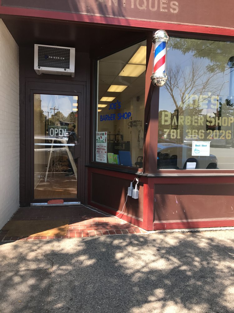 Barber cutting a client's hair inside Joe's Barber Shop in Newtonville MA
