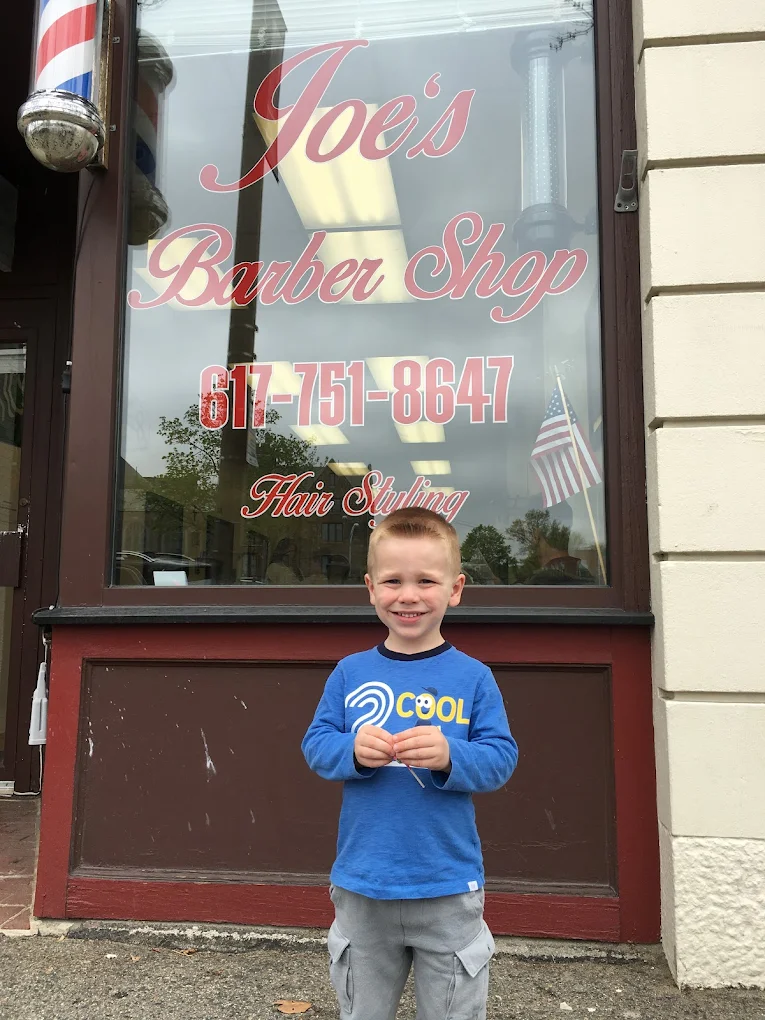 Happy customer with a fresh haircut outside Joe's Barber Shop in Newtonville MA