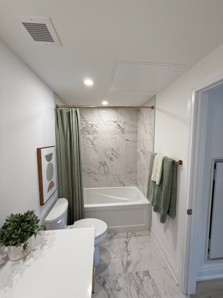 Bathroom with marble tile and gold towel bar
