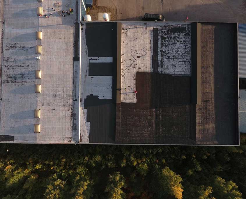 SprayGrade applied seamless black liquid-rubber coating on commercial metal roof