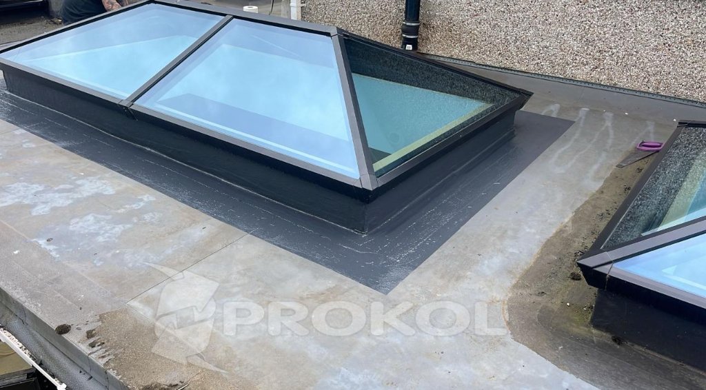 Contractor applying repair sealant to localised roof defect