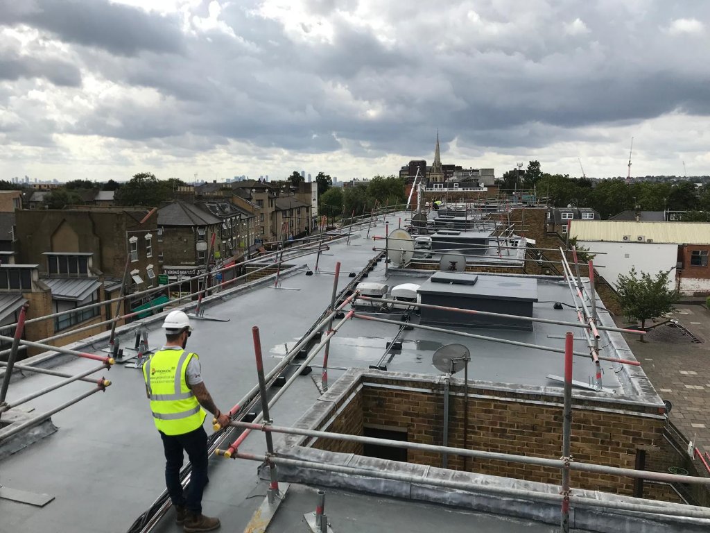 Rocathaan HotSpray urban flat roof overview — spray-applied polyurea waterproofing