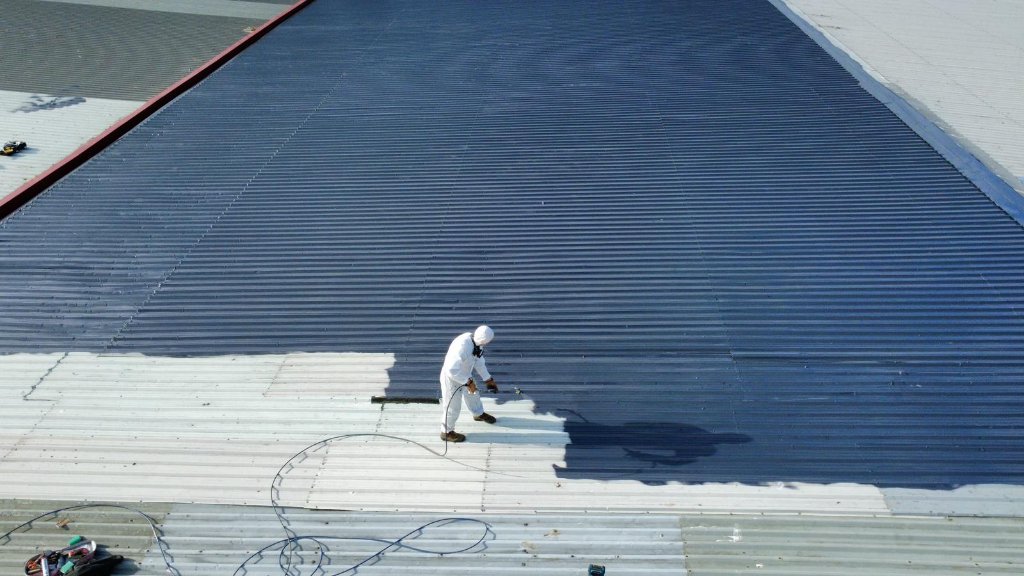 Airless spray application of aliphatic topcoat on commercial roof surface