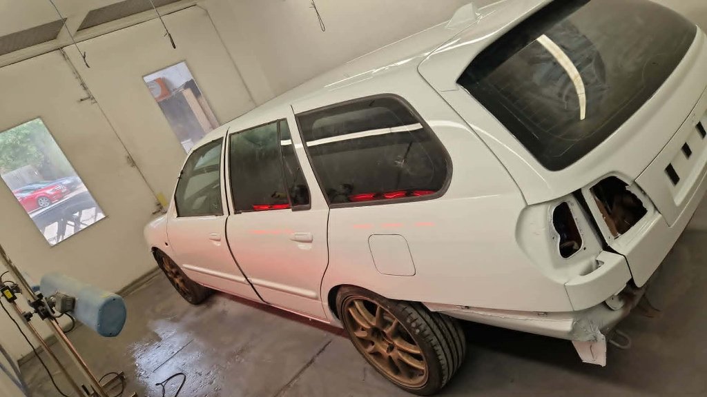 White estate side view in spray booth during respray preparation — M&M Vehicle Repairs Tewkesbury