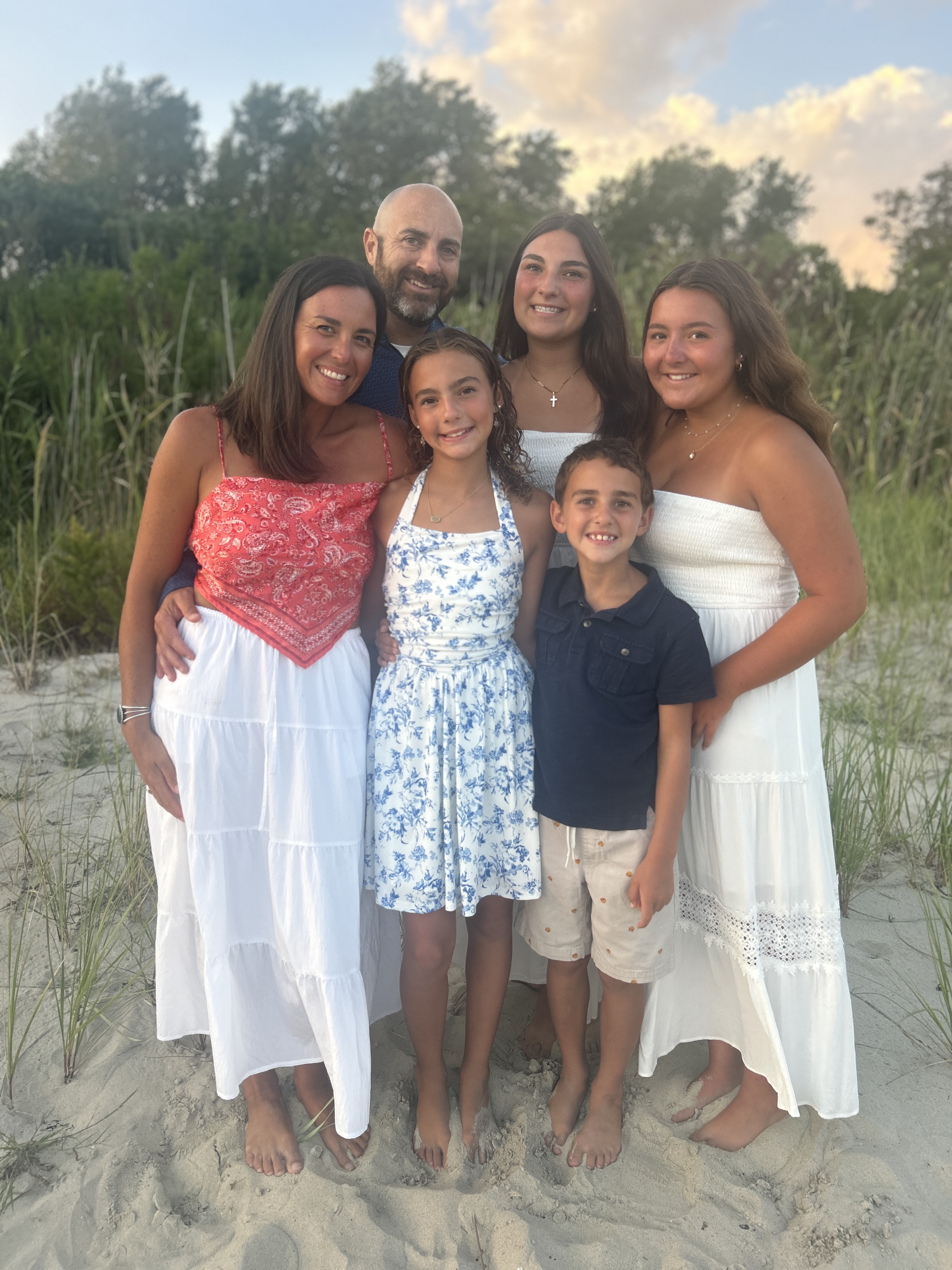 The Supper Cycle family posing together on the beach at sunset