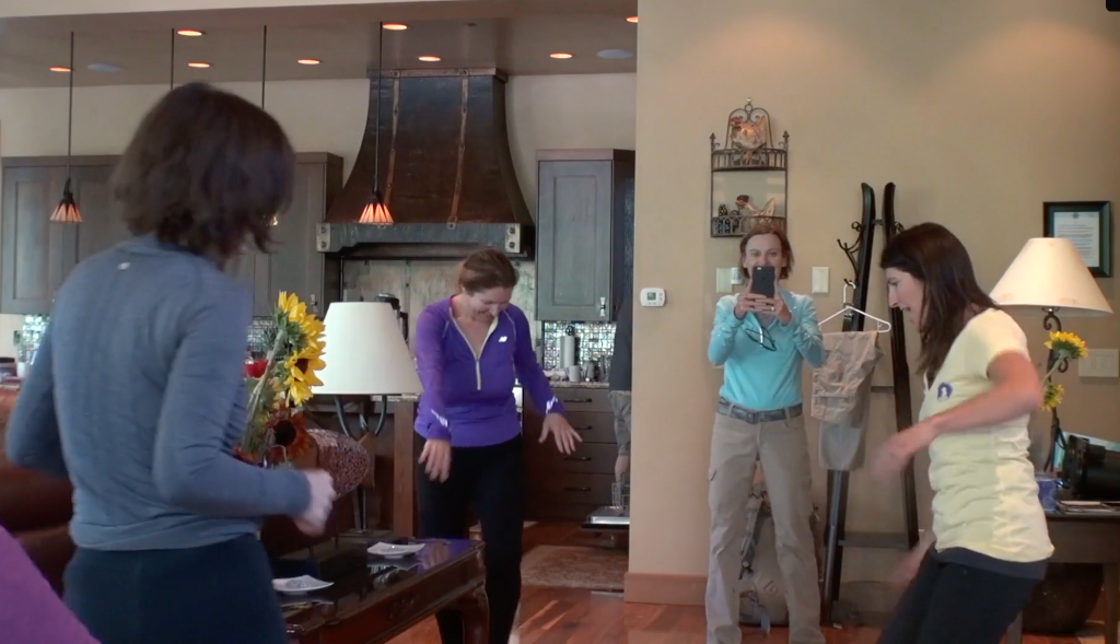 Women dancing and laughing together indoors at the retreat house