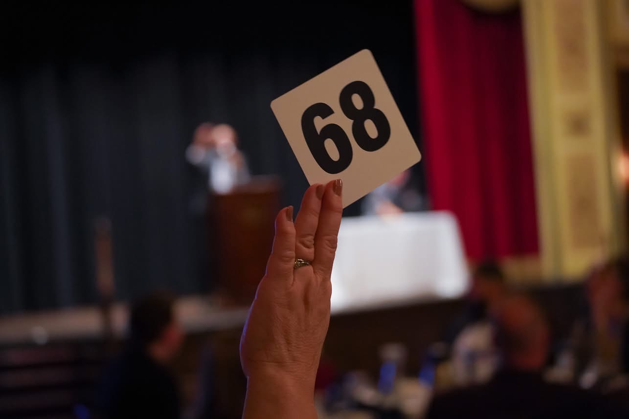 Guest holding up a numbered bidding paddle