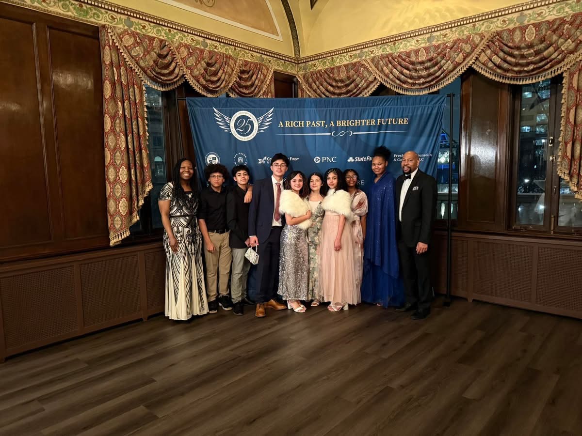 Group photo before branded step-and-repeat banner