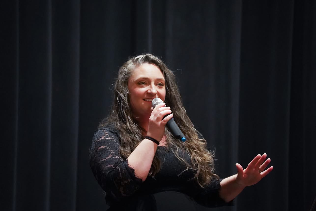 Woman speaking into a microphone on stage